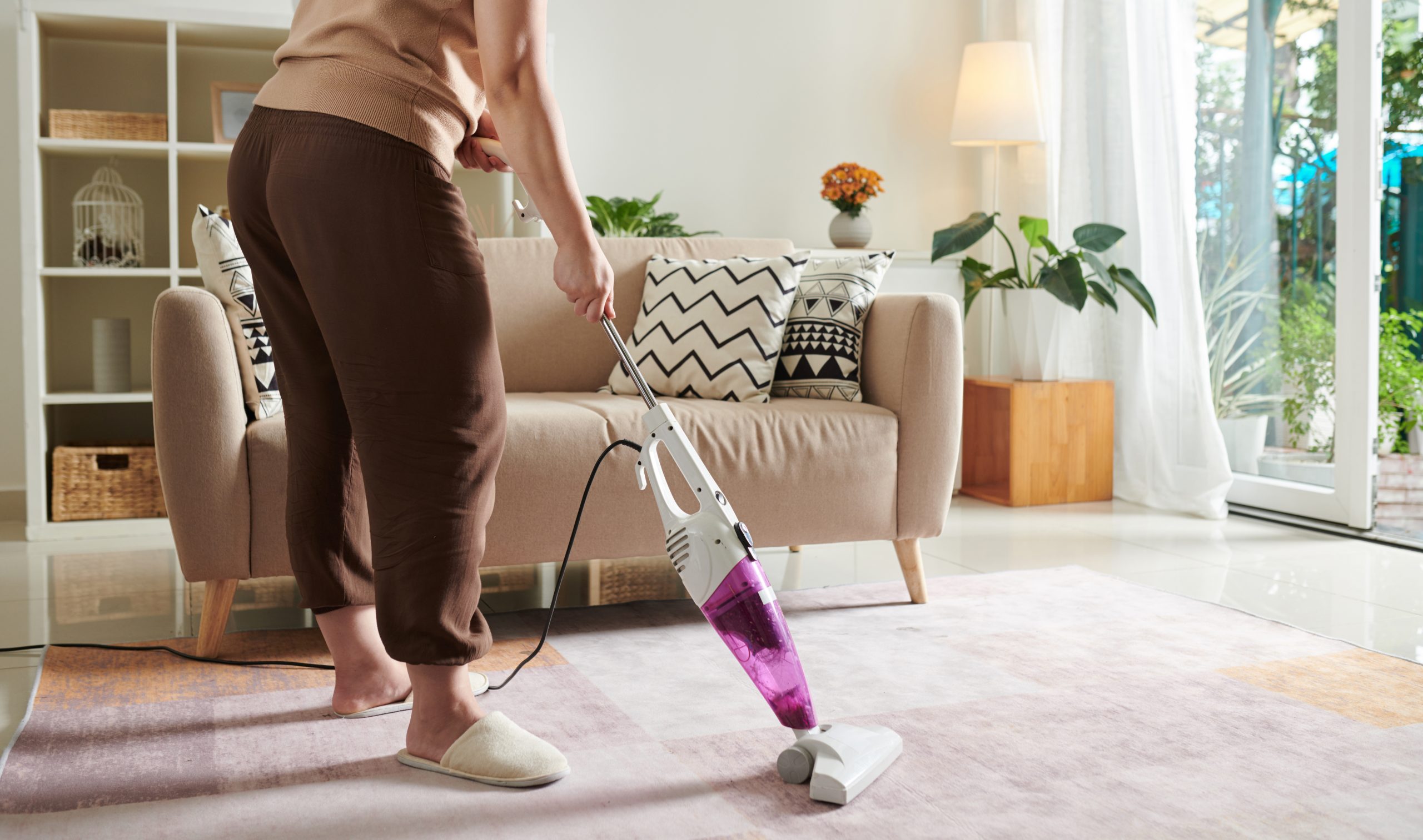 Woman using vacuum cleaner to clean the room